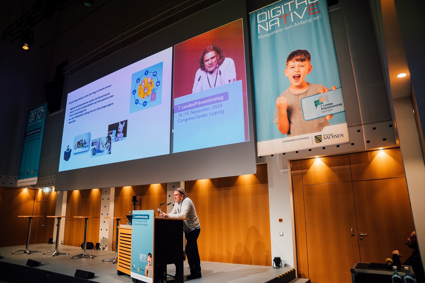 Prof. Dirk Labudde referiert hinter einem Pult vor einer großer Leinwand, auf der seine Präsentation zu sehen ist